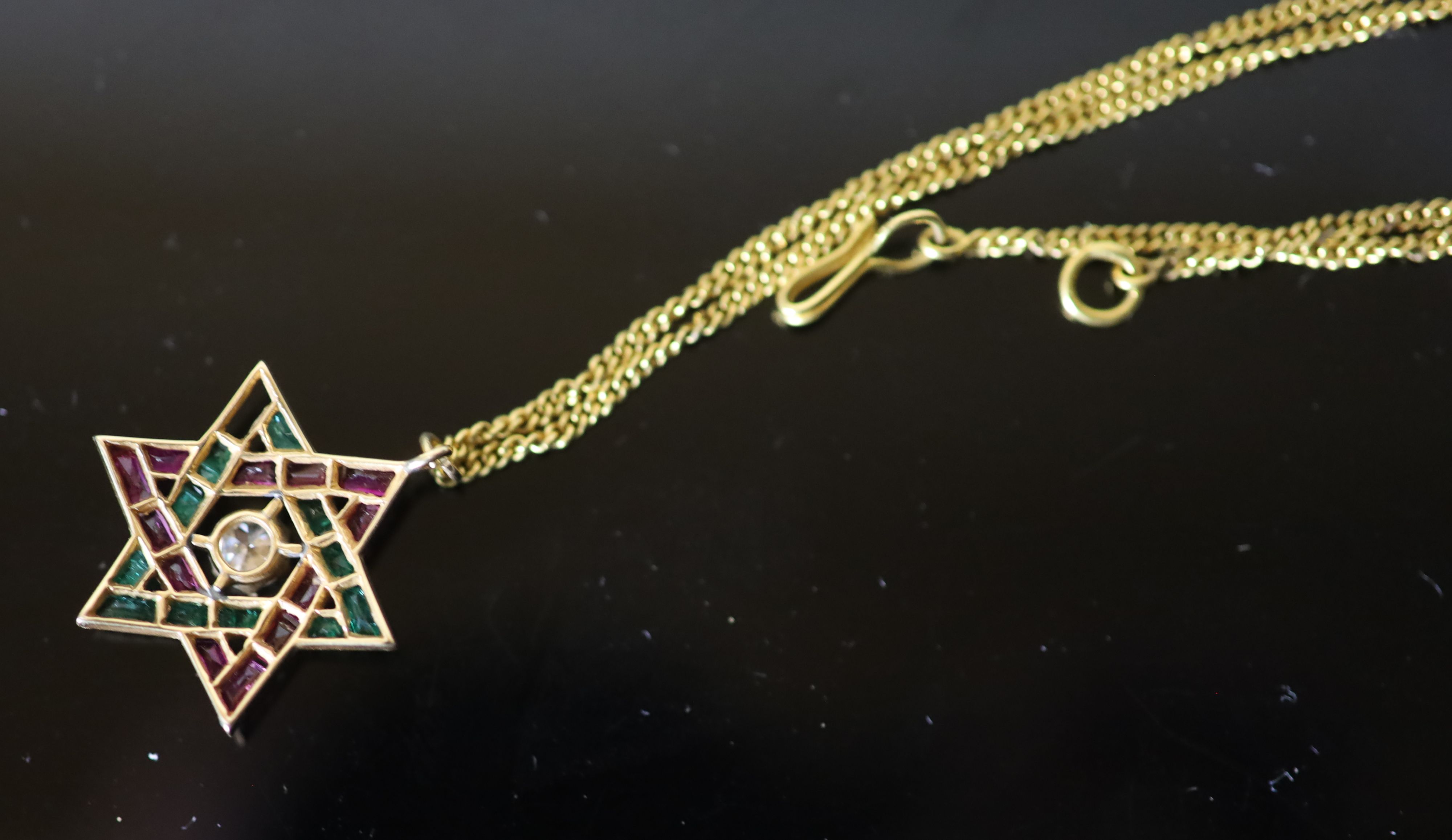 A continental gold, emerald, ruby and diamond set Star of David pendant, on a gold fine link chain,